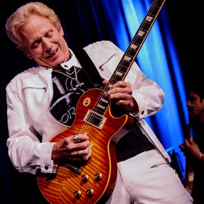 Don Felder playing guitar at his concert.